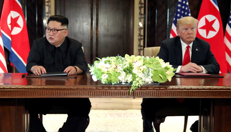 Donald Trump und Kim Jung-un in Singapur an einem Tisch.