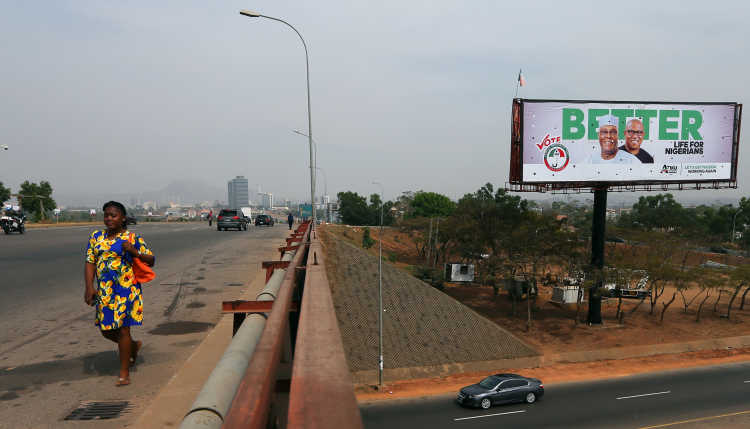 Eine große Straße in Nigeria mit einem Wahlplakat.