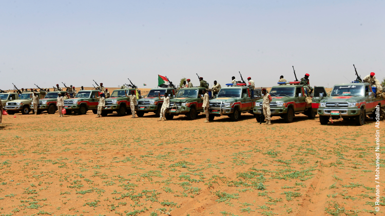 Members of Sudanʼs paramilitary Rapid Support Forces stand next to vehicles during an operation to locate and arrest Irregular migrants from Ethiopia, Sudan, and Chad who were abandoned near the Libyan border and taken to the Khartoum State border, Sudan
