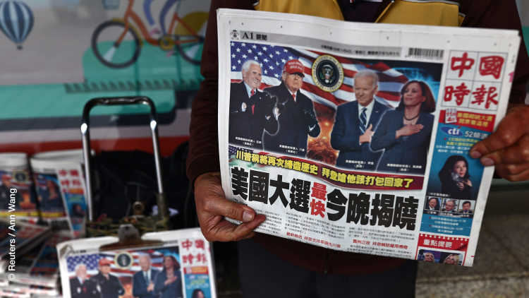 Ein Mann verkauft Zeitungen mit Artikeln über die US-Wahl auf der Titelseite entlang einer Straße in Taipeh, Taiwan.