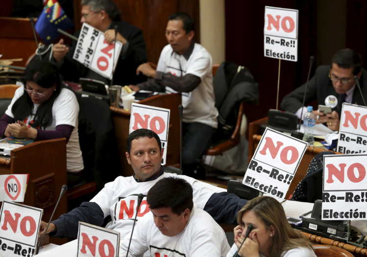Opposition members of Bolivia's parliament protest with posters saying "No Re-Re Election".