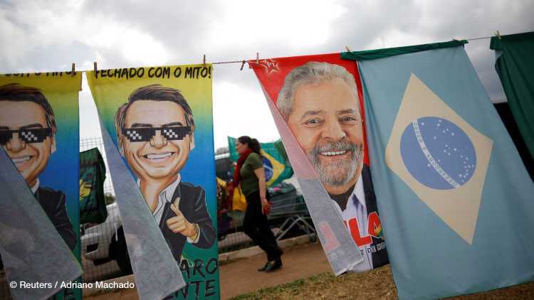 Eine Frau geht an Wahlkampfmaterialien vorbei, auf denen der ehemalige brasilianische Präsident Luiz Inacio Lula da Silva und Präsident Jair Bolsonaro abgebildet sind, in Brasilia, Brasilien, 23. September 2022.