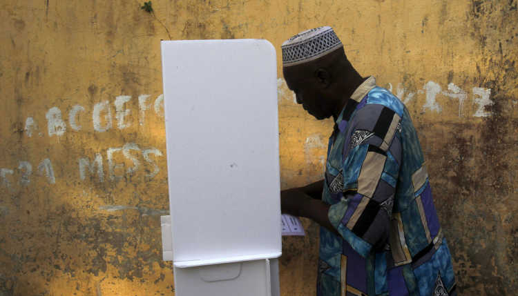 Ein Mann in einer Wahlkabine in Guinea.