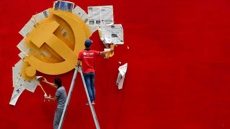 Arbeiter schälen Papiere von einer Wand, während sie die Flagge der Kommunistischen Partei Chinas im Nanhu-Revolution-Gedenkmuseum in Jiaxing, Zhejiang, neu bemalen
