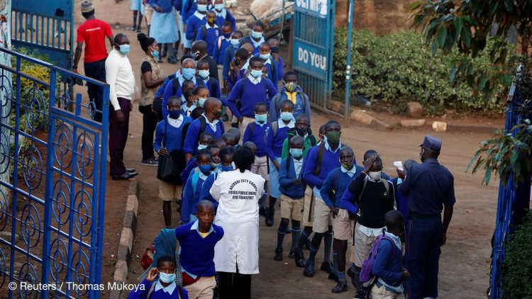 A worker checks the temperature of schoolchildren after the coronavirus disease (COVID-19) outbreak in Nairobi, Kenya.