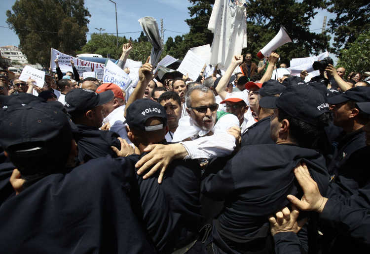 Demonstranten treffen auf eine Polizeisperre in Algerien.