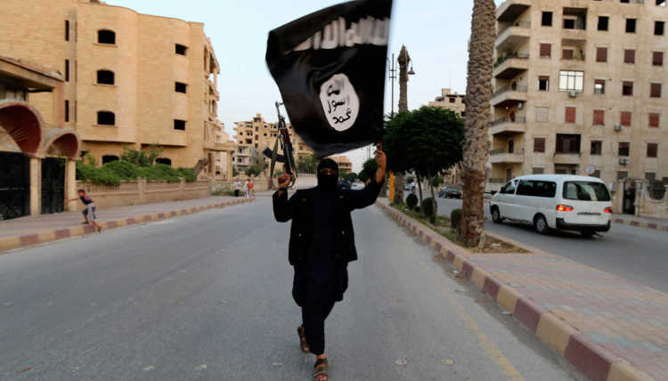 Ein Mitglied des Islamischen Staates im Irak und in der Levante (ISIL) schwenkt eine ISIL-Flagge in Raqqa.
