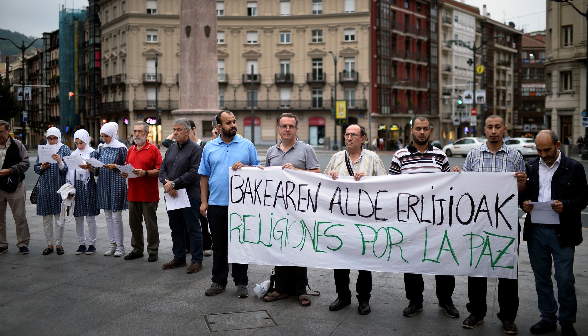 Demonstranten halten ein Transparent auf dem Religionen für den Frieden steht