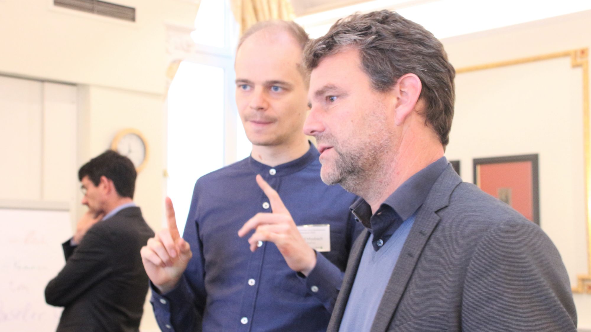 Participants of Leibniz Environment and Development Symposium 2022 chat during poster session in conference room at Baseler Hof, Hamburg.