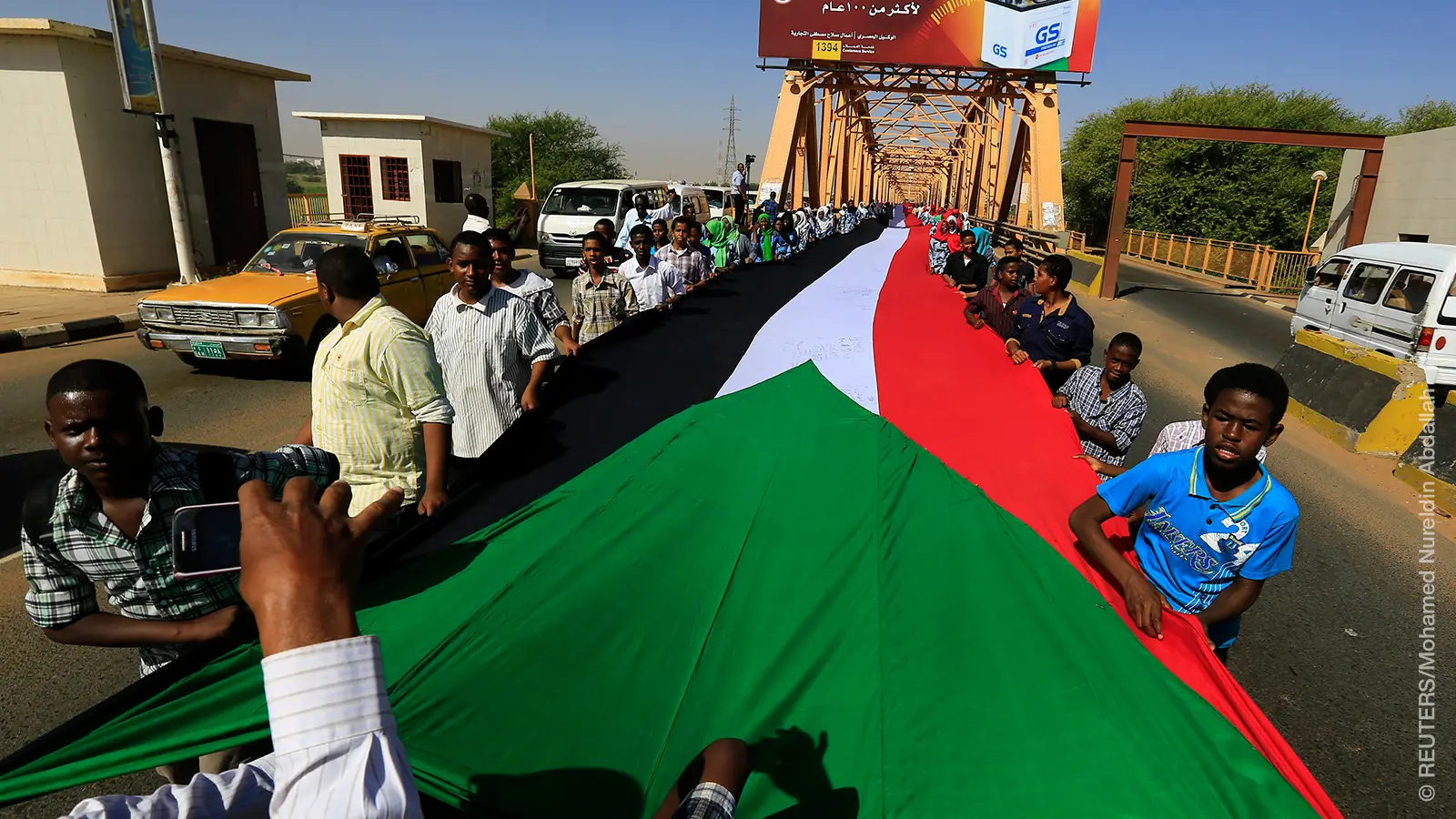 Students carry Sudan's national flag as they pass the River Nile during celebrations to mark Sudan's 59th Independence Day, in Khartoum January 1, 2015. Sudan became independent on January 1, 1956. REUTERS/Mohamed Nureldin Abdallah