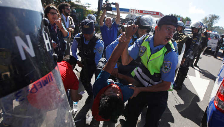 Polizisten nehmen einen Demonstranten in Honduras fest.