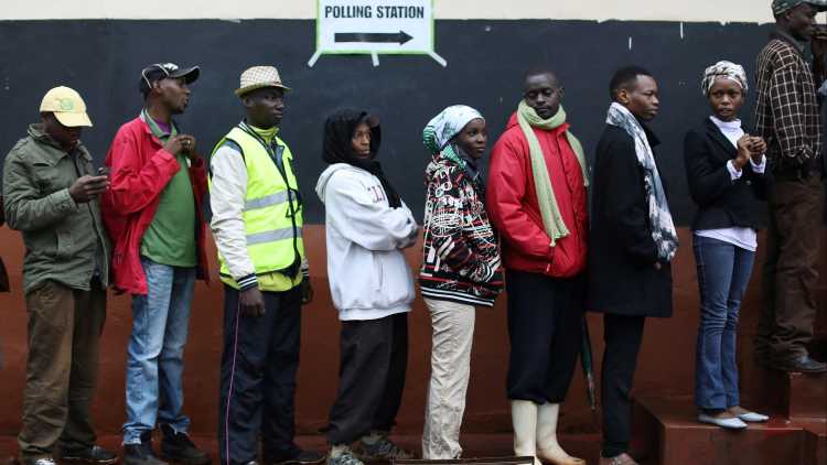 People queue to cast their vote at a polling station during a presidential election re-run in Gatundu, Kenya