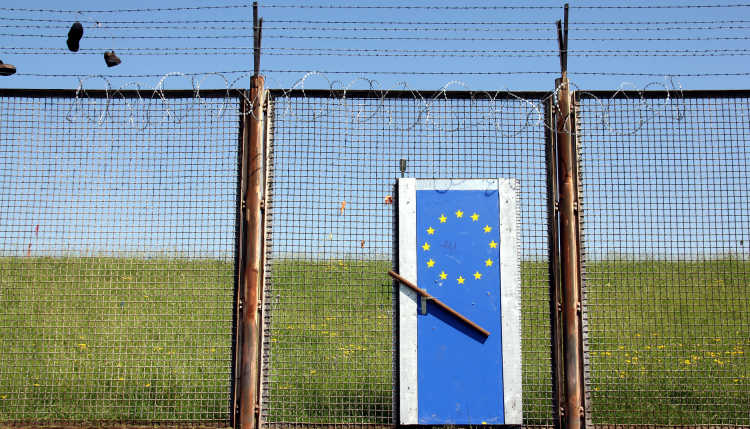 A European Union border fence with a locked door.