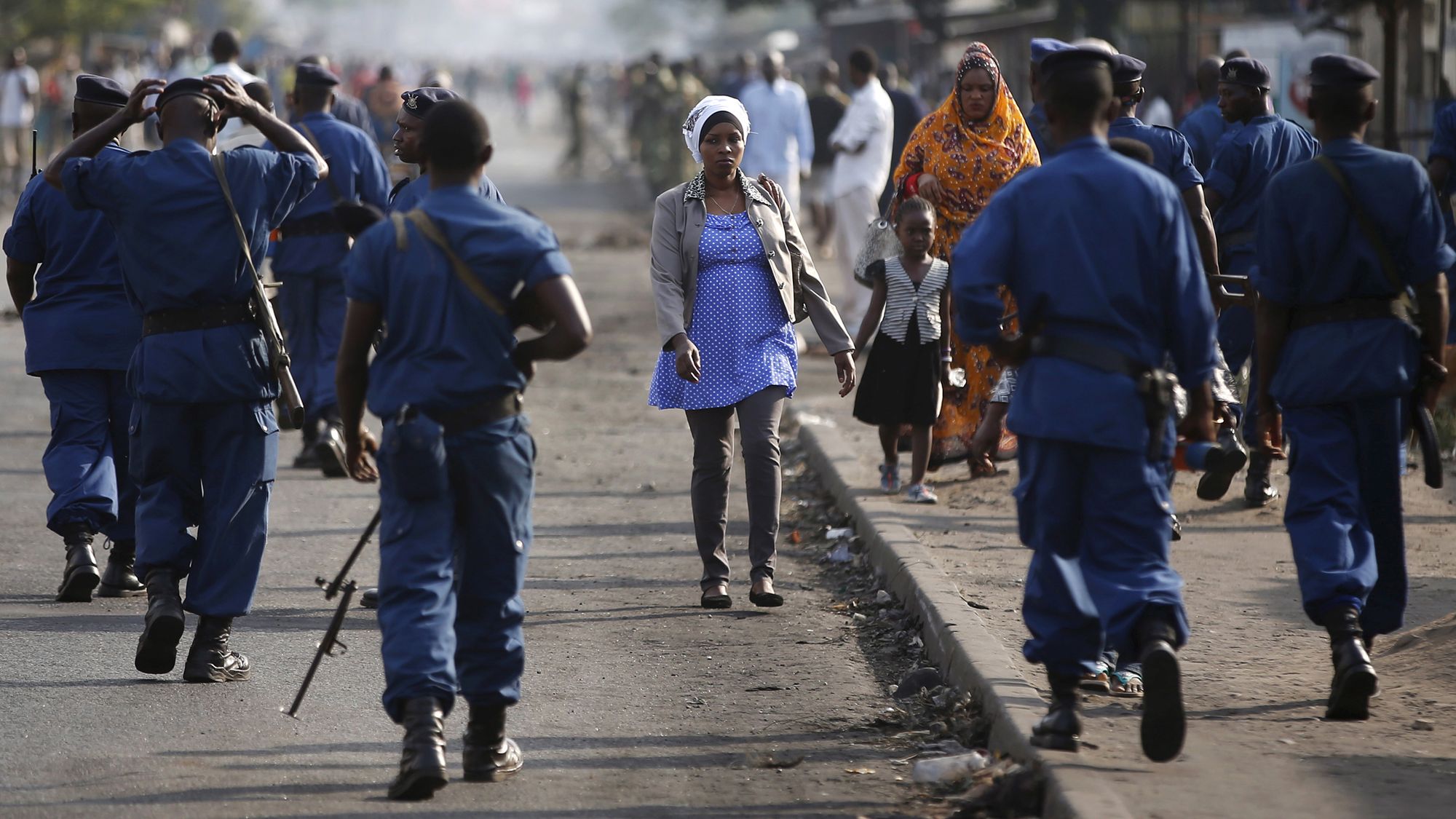 Eine Frau geht während einer Demonstration in Bujumbura an Polizisten vorbei