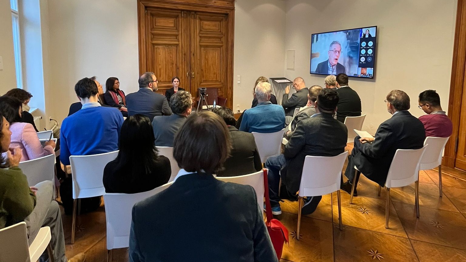 Photo of the event room during the GIGA Talk on Myanmar on 9 February 2023. Audience sitting in front of the panel and monitor, which displays online audience.