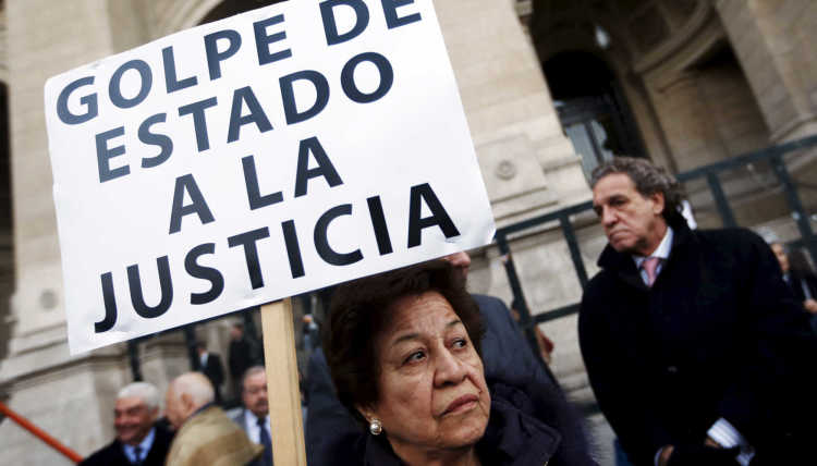 Eine Frau hält ein Plakat mit der Aufschrift "Staatsstreich für die Gerechtigkeit" in Buenos Aires, Argentinien, hoch.