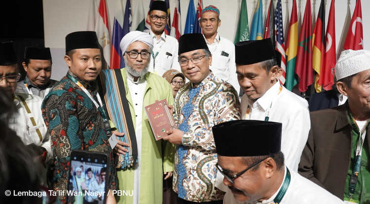 Gus Yahya, leader of Nahdlatul Ulama, at the international conference in Surabaya on 6 February 2023. He receives an Arabic book entitled “Be alert! Your religion is jeopardised!” and positions itself against puritanic Islamic streams.