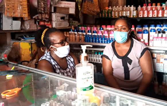 Zwei Frauen stehen mit Gesichtsmaske in einem Laden in Uganda. 