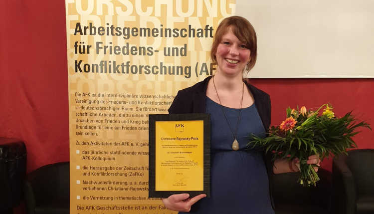 Elisabeth Bunselmeier with certificate and bouquet of flowers