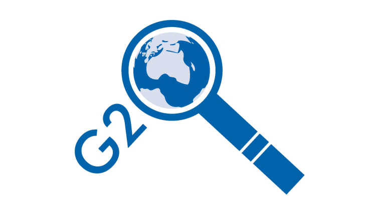 Logo G20 des GIGA: die Weltkugel unter einer Lupe.