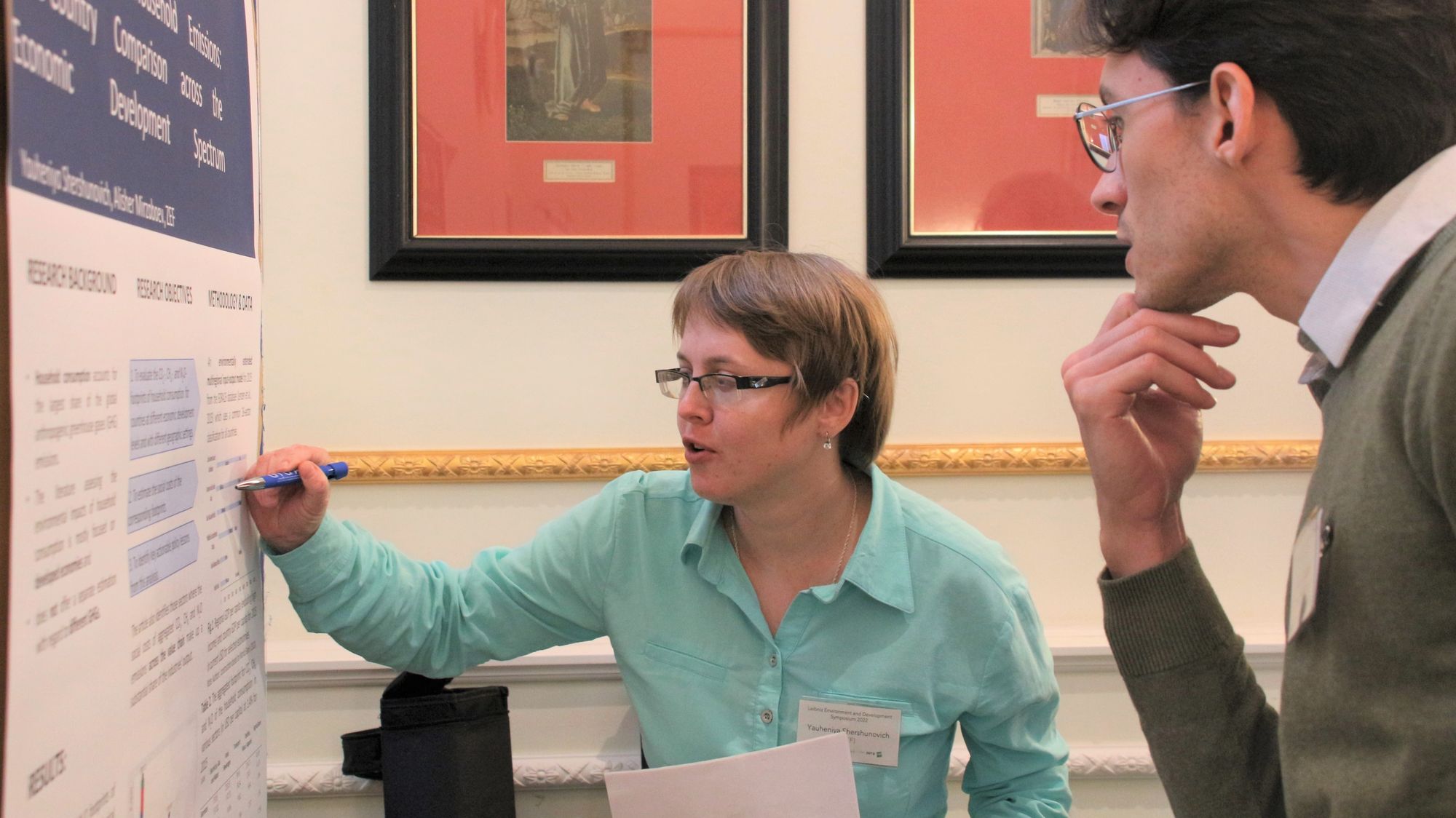 Participants of Leibniz Environment and Development Symposium 2022 chat during poster session in conference room at Baseler Hof, Hamburg.