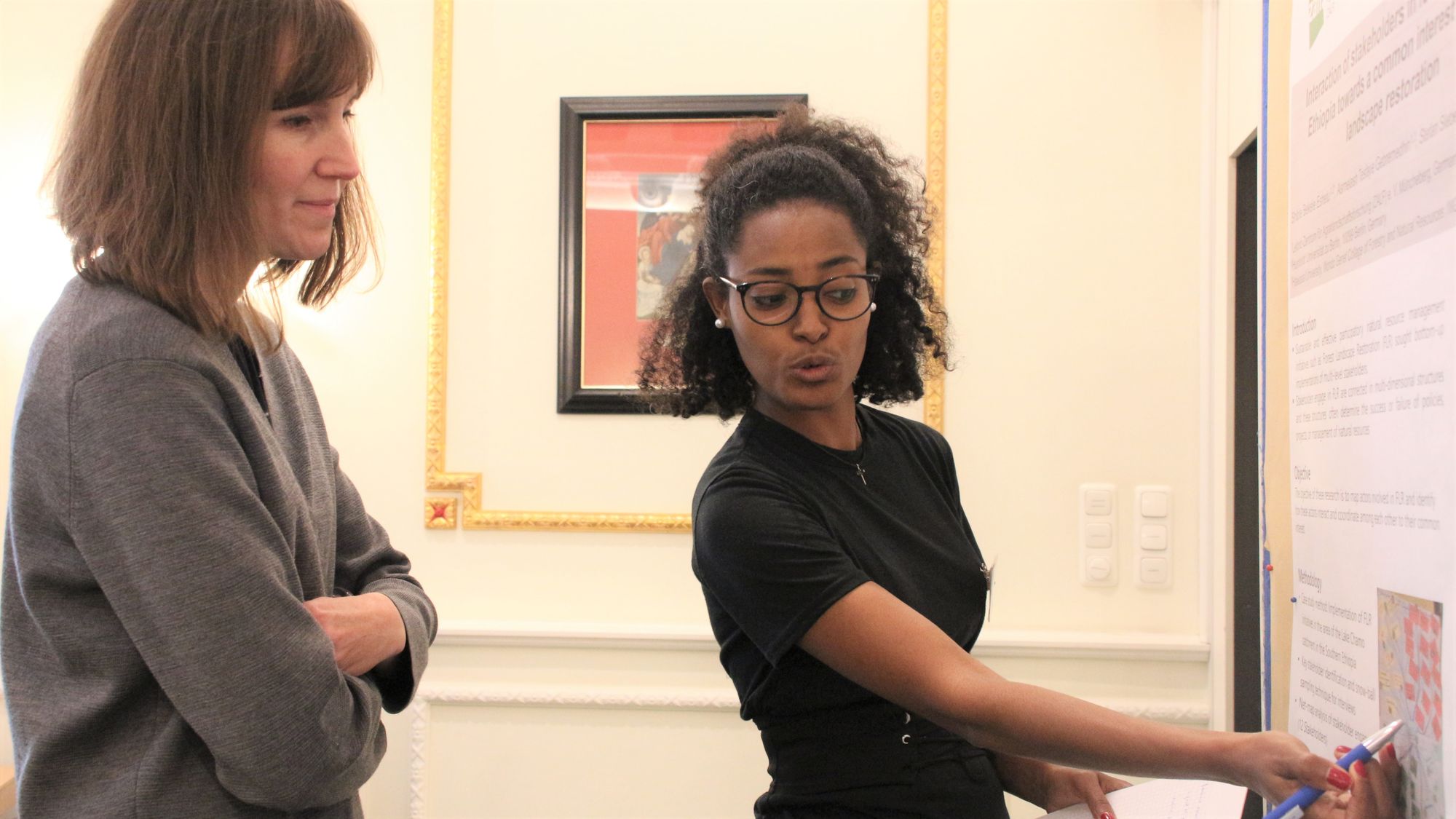 Participants of Leibniz Environment and Development Symposium 2022 chat during poster session in conference room at Baseler Hof, Hamburg.