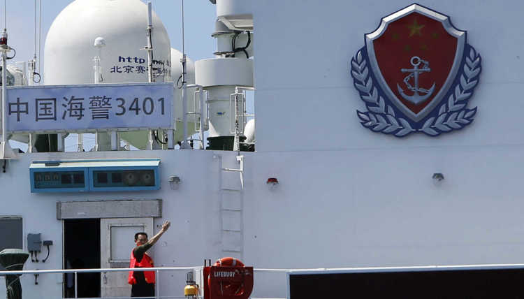 A crew member of a Chinese Coast Guard ship signals to leave the area at the disputed Second Thomas Shoal, part of the Spratly Islands, in the South China Sea.