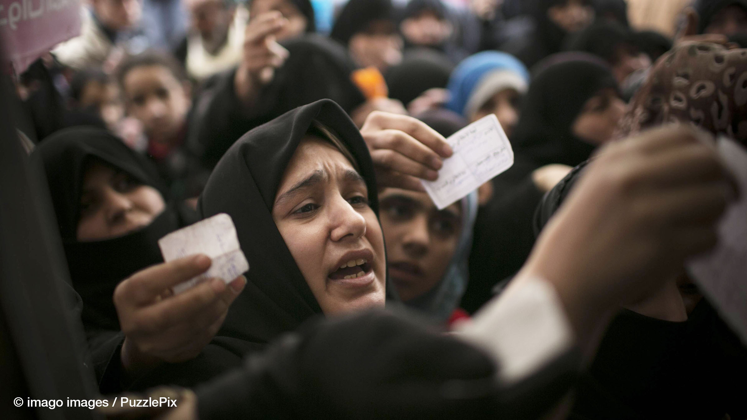 Syrische Zivilisten stehen Schlange, um Lebensmittelpakete des UNHCR im Stadtteil Alfartos 2013 in Aleppo, Syrien, abzuholen.