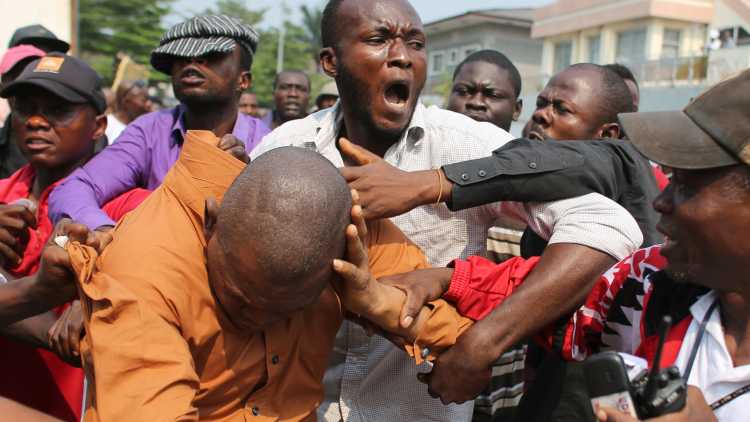 Opposition supporters beat a man in front of opposition party Union for Democracy and Social Progress (UDPS) office in Kinshasa, Democratic Republic of Congo