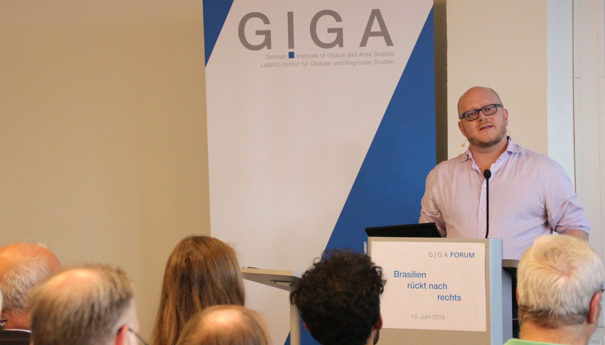 Foto von Prof. Dr. Kai Michael Kenkel auf Podium vor Publikum